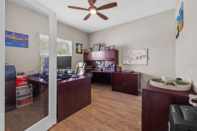 home office with light hardwood / wood-style floors and ceiling fan