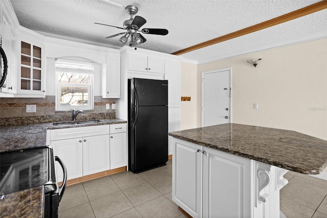 kitchen featuring sink, white cabinetry, range with electric cooktop, a textured ceiling, and black fridge