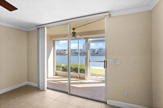 doorway to outside with a water view, ceiling fan, crown molding, and light tile patterned flooring