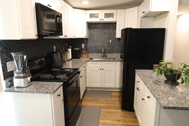 kitchen featuring light hardwood / wood-style floors, white cabinetry, sink, and black appliances