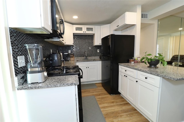 kitchen with white cabinetry, light wood-type flooring, and decorative backsplash