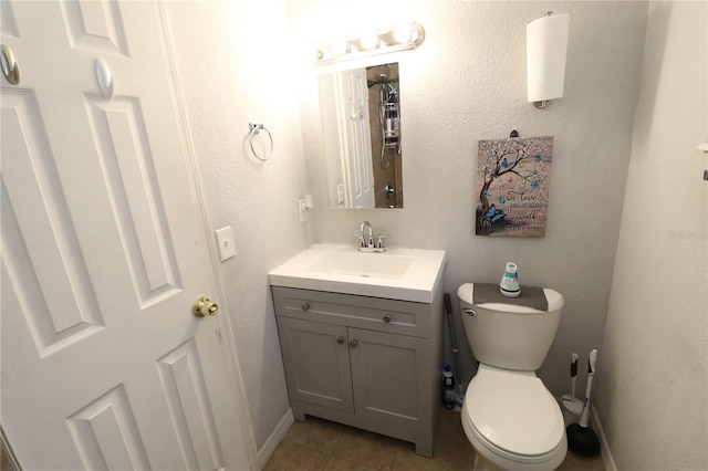 bathroom featuring toilet, vanity, and tile patterned floors