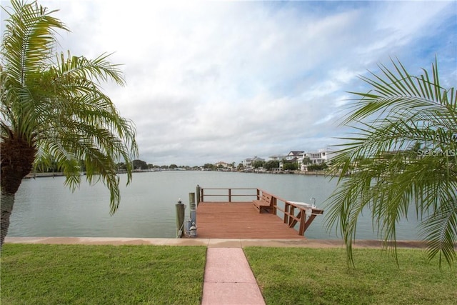 view of dock with a water view and a lawn