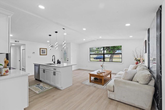 living room with light hardwood / wood-style floors, lofted ceiling, and sink