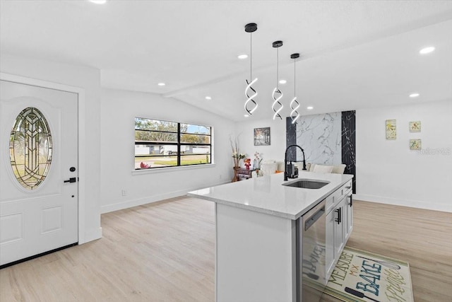 kitchen with pendant lighting, dishwasher, a kitchen island with sink, sink, and vaulted ceiling