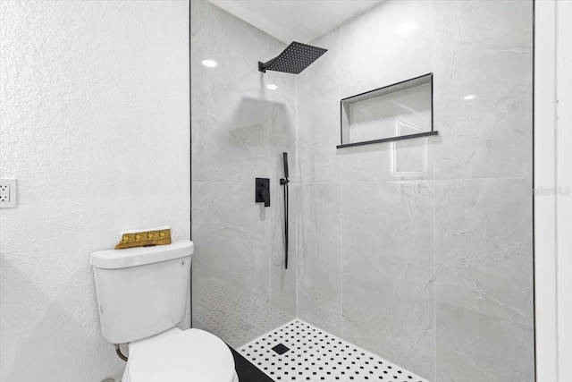 bathroom featuring toilet and tiled shower