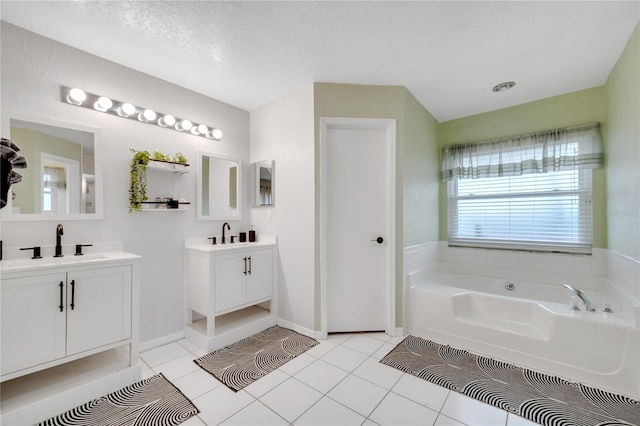 bathroom featuring vanity, a tub, tile patterned floors, and a textured ceiling