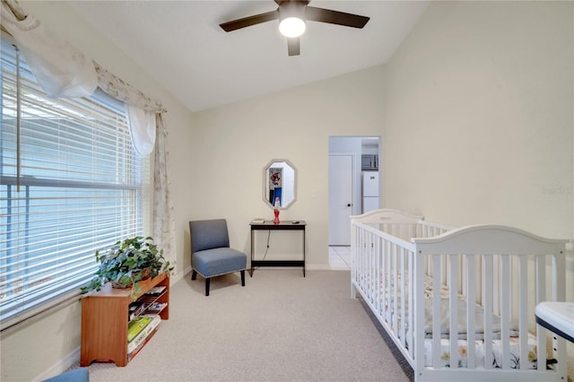 carpeted bedroom with lofted ceiling, a nursery area, white refrigerator, and ceiling fan