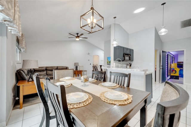 dining space with high vaulted ceiling, ceiling fan with notable chandelier, and light tile patterned floors