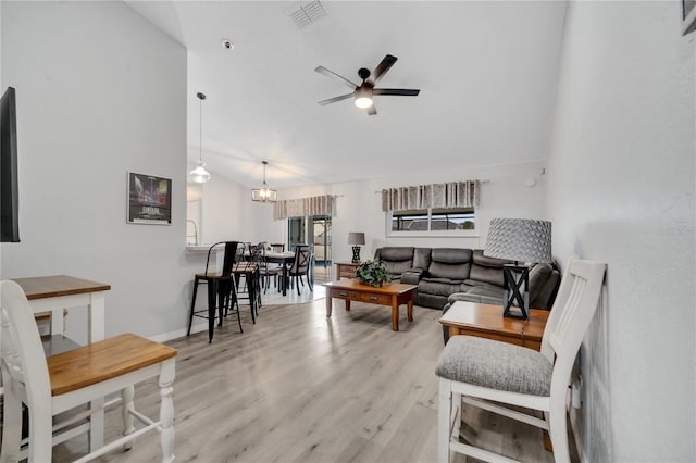 living room with light hardwood / wood-style flooring and ceiling fan with notable chandelier