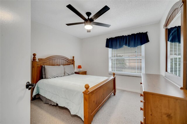 carpeted bedroom featuring a textured ceiling and ceiling fan