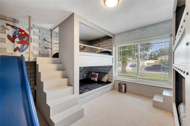 staircase with carpet and a textured ceiling