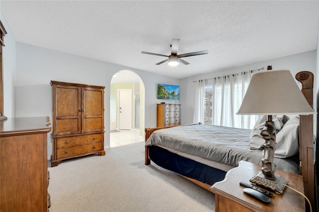 bedroom featuring ceiling fan, light carpet, and a textured ceiling