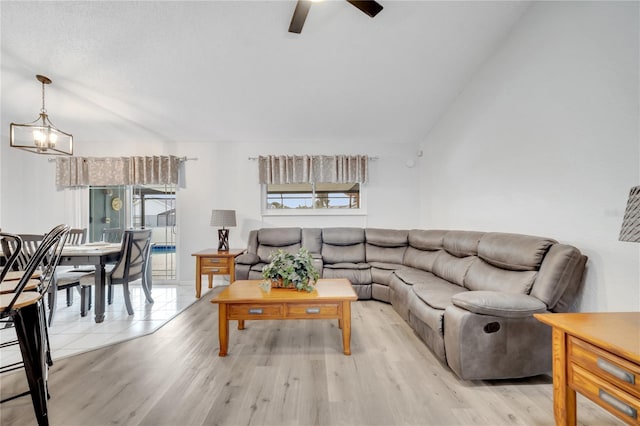 living room featuring ceiling fan with notable chandelier, light wood-type flooring, and a wealth of natural light