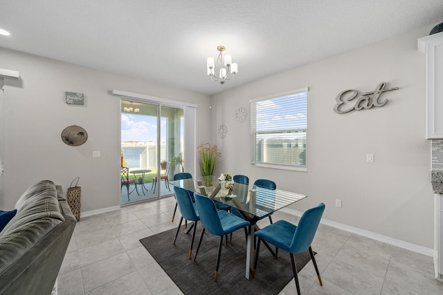 dining space with light tile patterned floors and an inviting chandelier