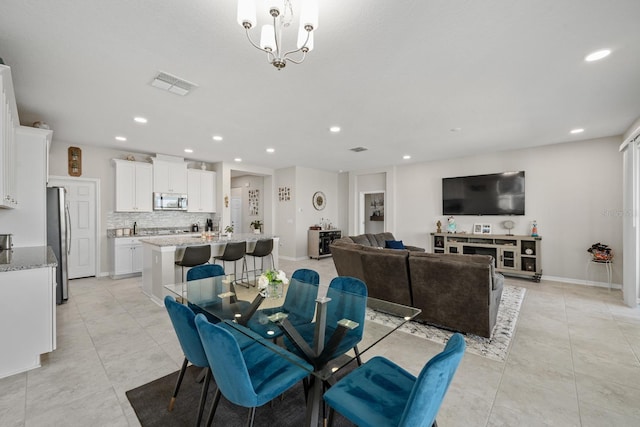 dining space with light tile patterned floors and a notable chandelier