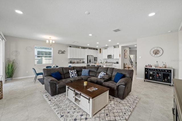 tiled living room with an inviting chandelier