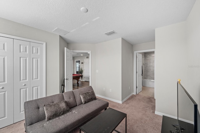 living room featuring light colored carpet, a textured ceiling, and billiards