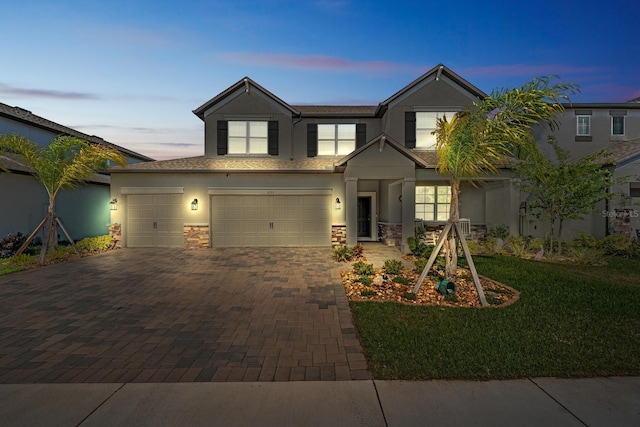 view of front of house featuring a garage and a yard