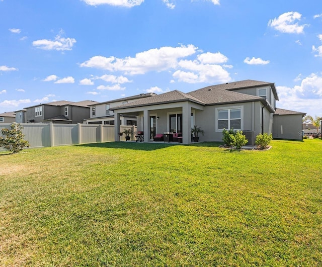 back of house featuring a lawn, central AC unit, and a patio