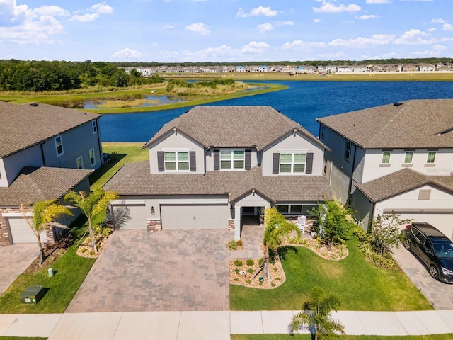 view of front of property with a garage and a water view