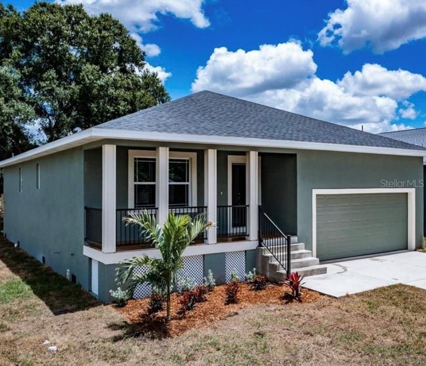 107 6th Ave NW, Ruskin, FL 33570 - view of front of home featuring covered porch, stucco siding, a garage, and roof with shingles