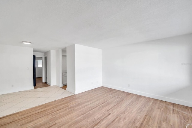 empty room featuring a textured ceiling and light wood-type flooring