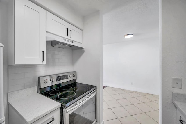 kitchen featuring white cabinetry, stainless steel electric range oven, tasteful backsplash, light stone counters, and light tile patterned floors