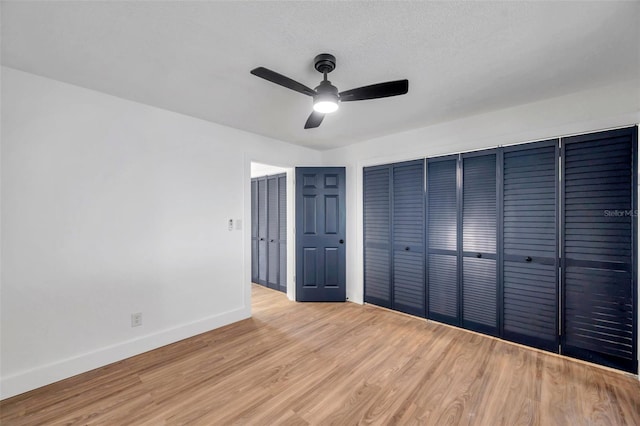 unfurnished bedroom with ceiling fan, a textured ceiling, and light wood-type flooring