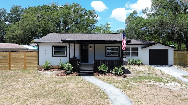 view of front facade with a front yard, a garage, and a porch