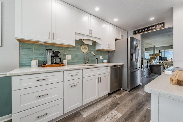 kitchen with white cabinetry, sink, decorative backsplash, appliances with stainless steel finishes, and dark hardwood / wood-style flooring