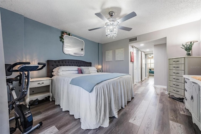 bedroom featuring ceiling fan, dark hardwood / wood-style floors, and a textured ceiling