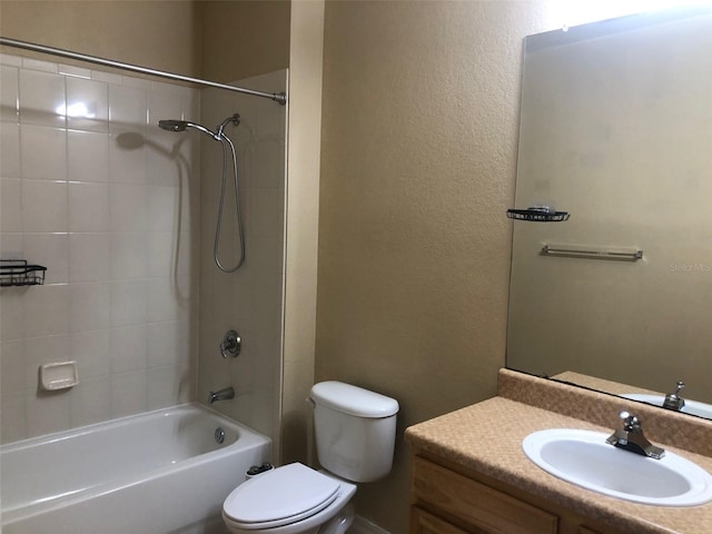 full bathroom with tiled shower / bath, vanity, and toilet