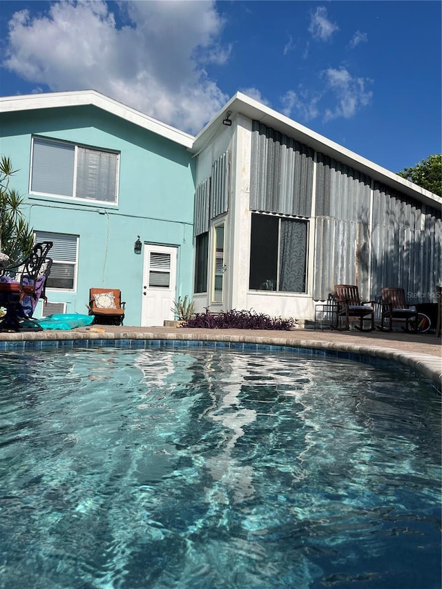 exterior space featuring an outdoor pool and stucco siding