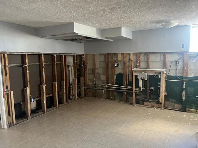 basement with a textured ceiling and tile patterned floors