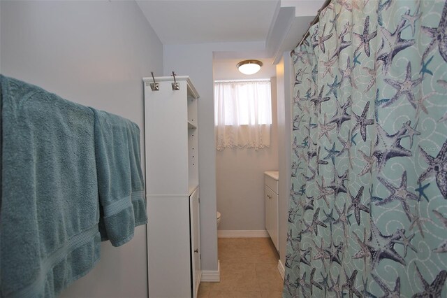 bathroom with baseboards, toilet, a shower with curtain, tile patterned floors, and vanity