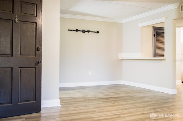 empty room featuring light hardwood / wood-style floors and crown molding