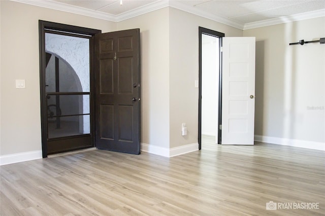 empty room with ornamental molding and light wood-type flooring