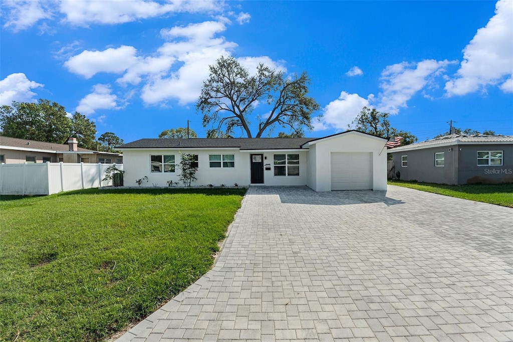 single story home featuring a front yard and a garage