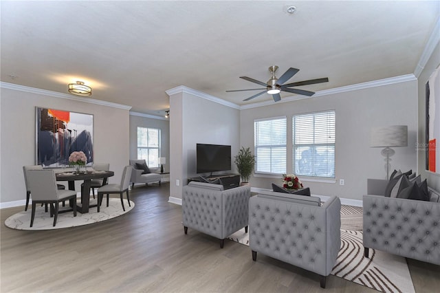 living room featuring wood-type flooring, ceiling fan, and crown molding