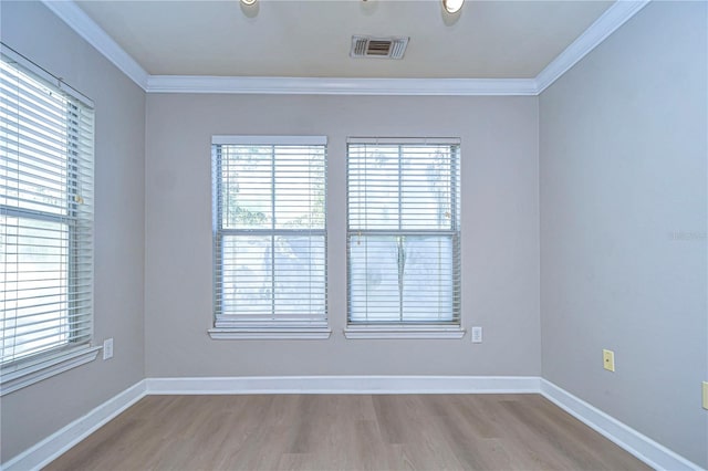 spare room featuring light hardwood / wood-style floors and crown molding