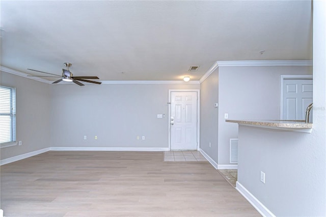 interior space featuring light wood-type flooring, ceiling fan, and ornamental molding