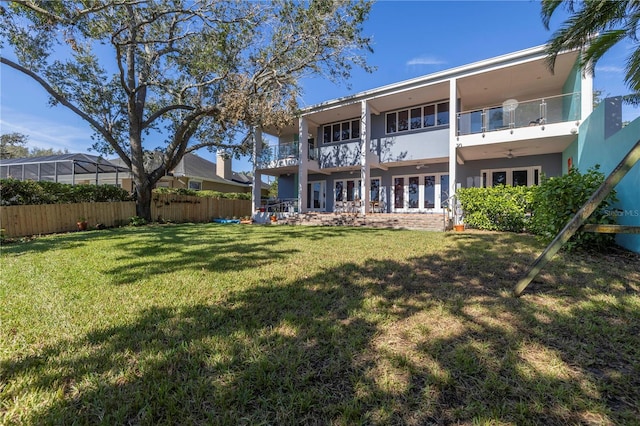 rear view of property with a lawn and a balcony