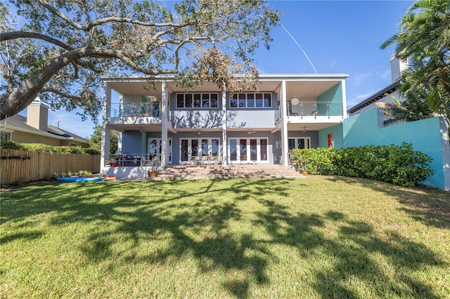 back of property featuring a lawn, a patio, and a balcony