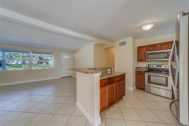 kitchen featuring stainless steel appliances, light tile patterned floors, and light stone counters