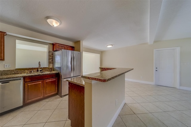 kitchen featuring a textured ceiling, sink, light tile patterned flooring, beam ceiling, and appliances with stainless steel finishes