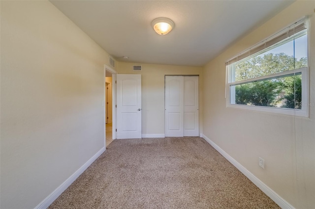 unfurnished bedroom with carpet flooring, vaulted ceiling, and a closet