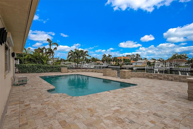 view of pool featuring a water view and a patio