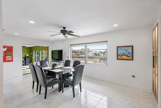 tiled dining space featuring ceiling fan and a textured ceiling