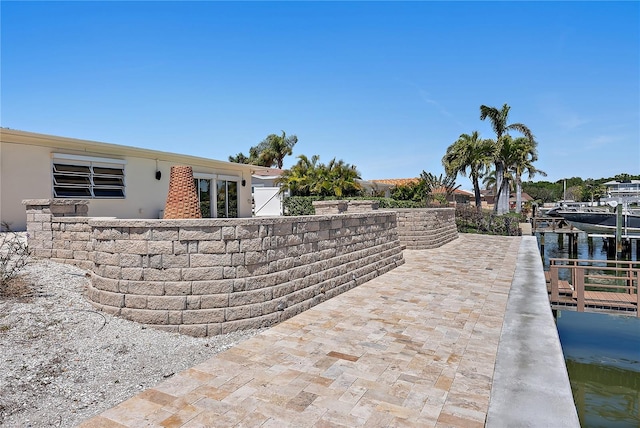 view of patio / terrace featuring a water view and a dock